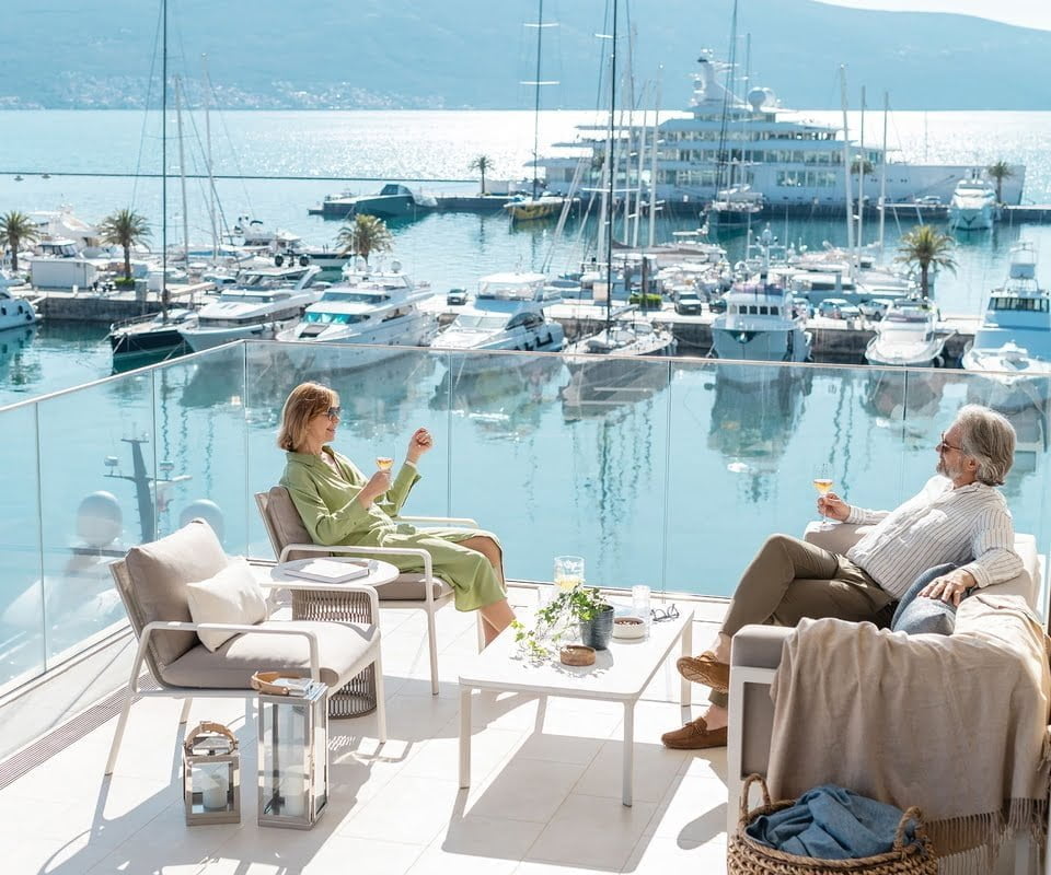 Couple sitting on balcony overlooking marina