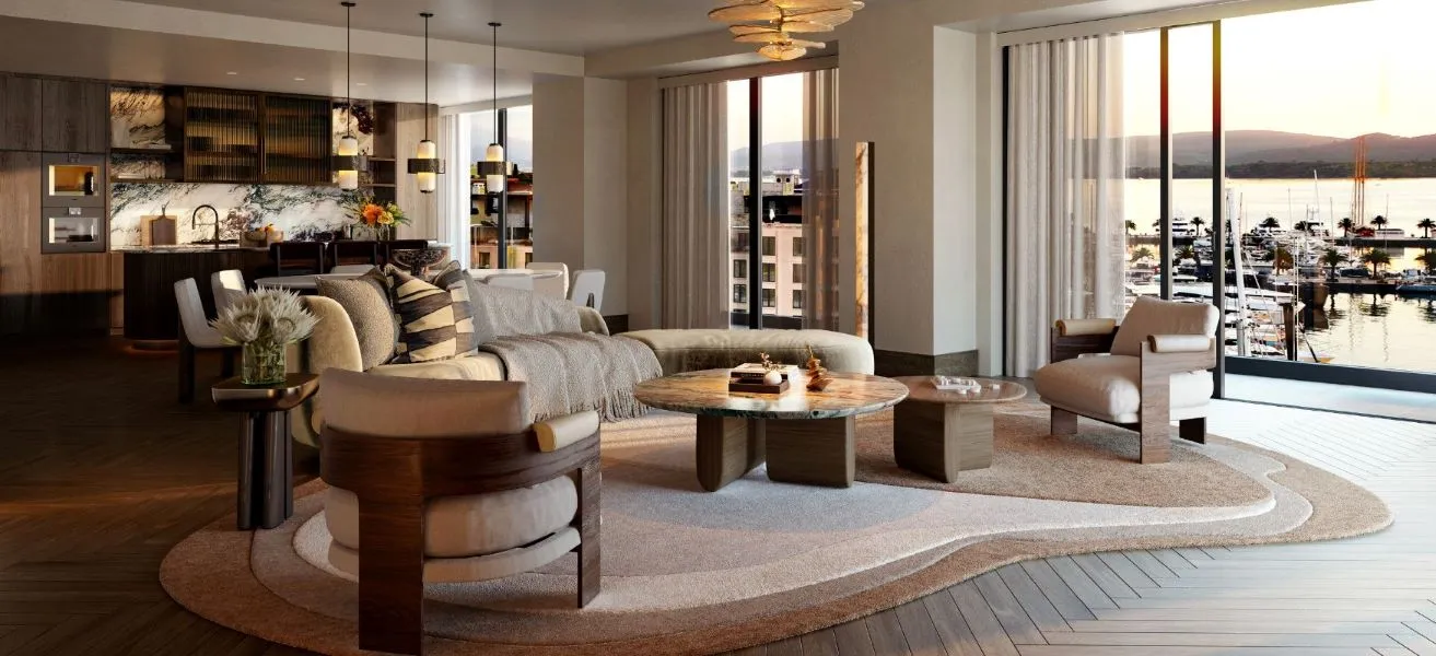 Stylish living room with contemporary furniture, a sophisticated chandelier, and large windows offering expansive views of a marina, creating a warm and inviting space for relaxation.